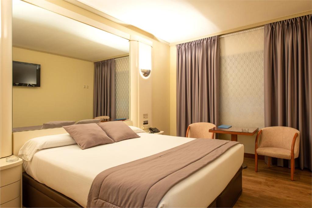 奥莱罗斯雅尔丹酒店 的酒店客房设有一张大床和一张书桌。