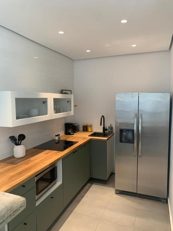圣胡安SOKZO Miramar的厨房配有不锈钢冰箱和木制柜台。