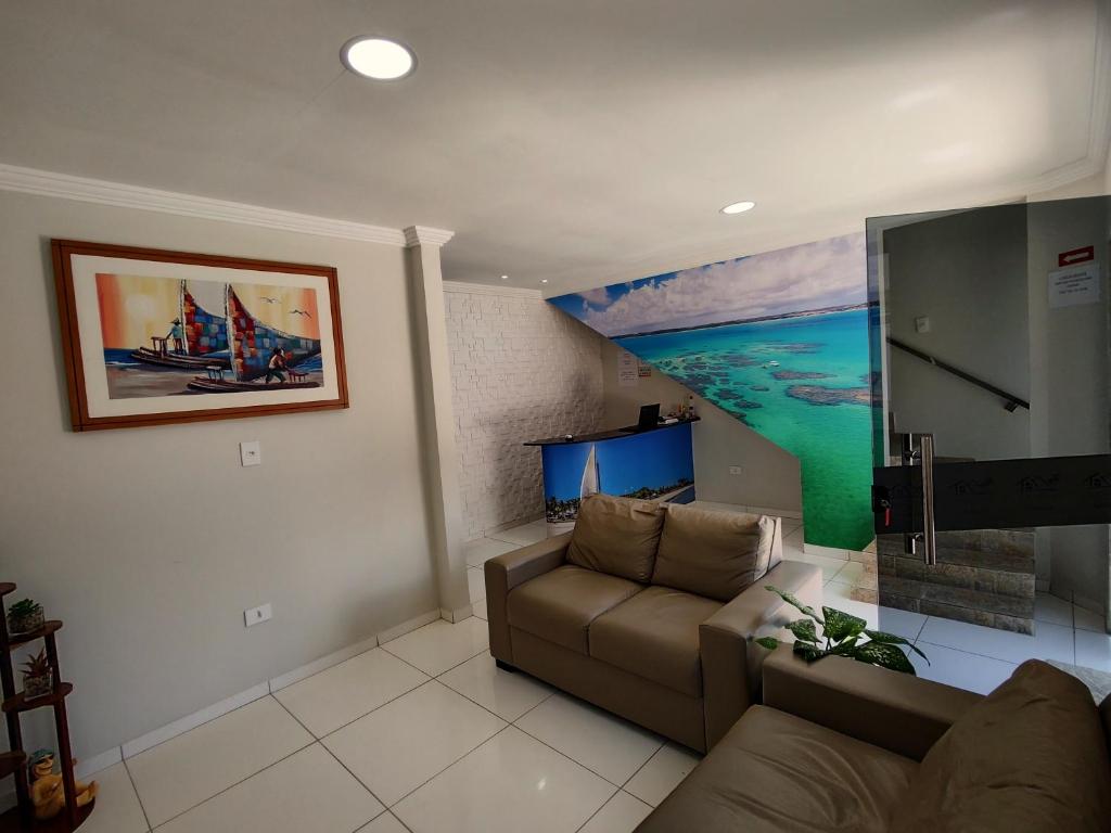 马拉戈日Pousada do Alemão的客厅配有沙发和小船绘画