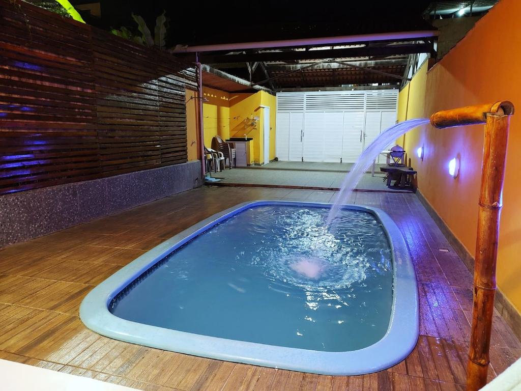 马拉戈日Casa com piscina no centro de Maragogi pertinho da praia!的客房内的热水浴池和喷泉