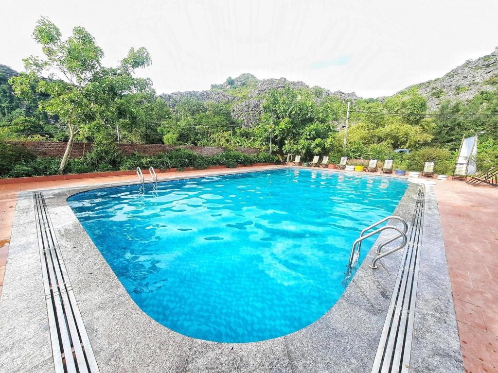 宁平Trang An Resort的蓝色的海水和山脉背景的游泳池