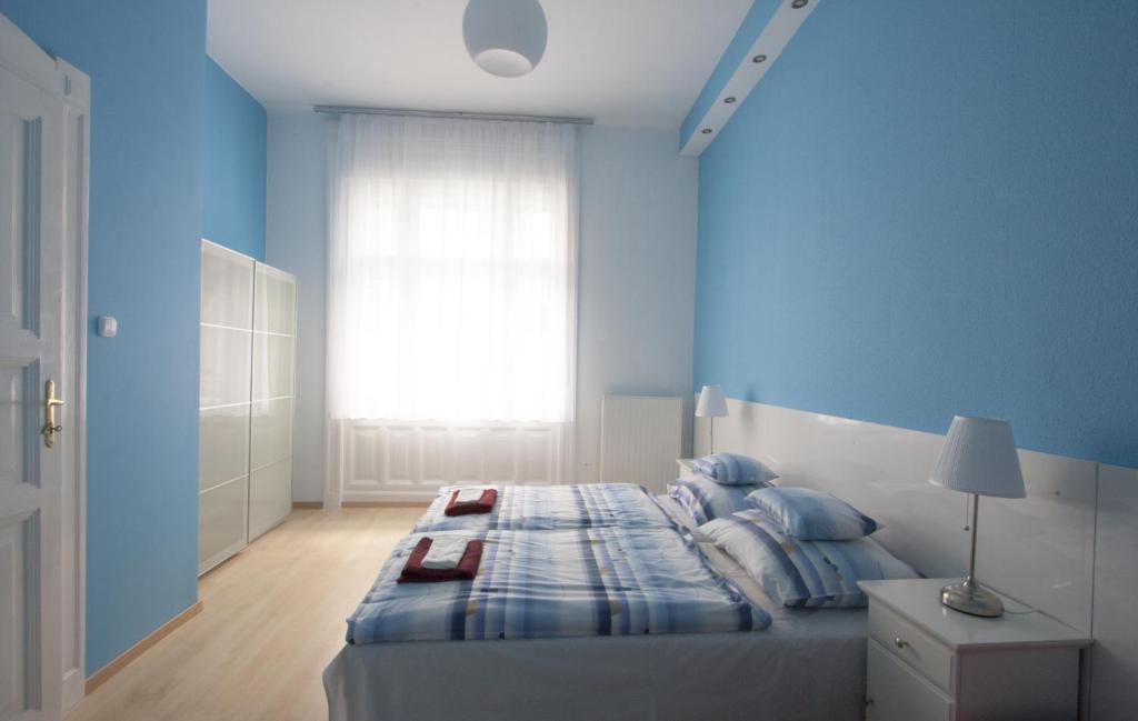 布达佩斯City Centre Apartment with 3 Bathrooms的蓝色的卧室设有床和窗户