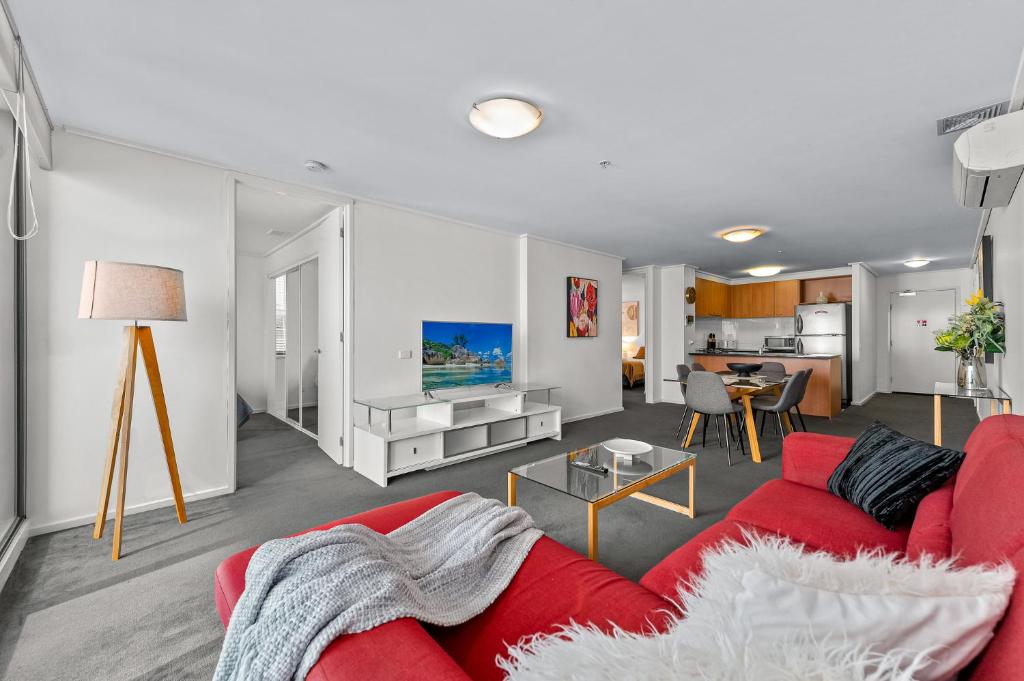 墨尔本独家住宿 - 萨米特公寓的客厅配有红色的沙发和桌子