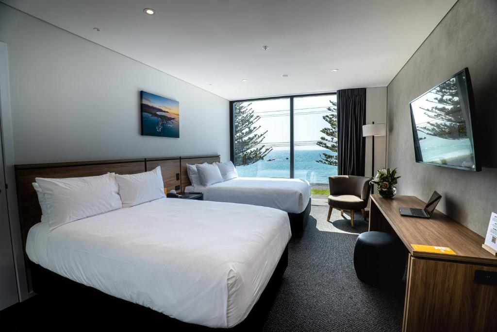 凯库拉Sudima Kaikōura的酒店客房配有两张床和一张书桌