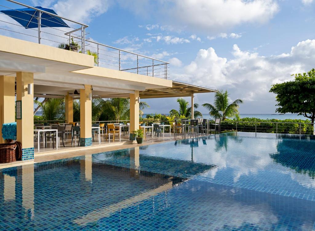 贝圣安那安卡菊海滩度假酒店的一个带桌椅的度假村游泳池
