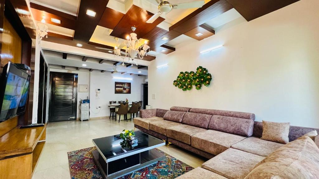 新德里橄榄服务公寓 - 格林公园的带沙发的客厅和用餐室