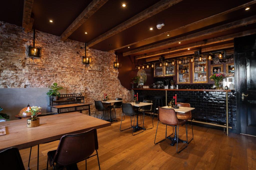阿姆斯特丹Hotel Hoksbergen的一间有桌椅和砖墙的餐厅