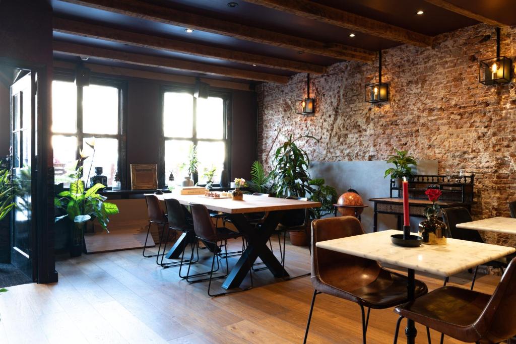 阿姆斯特丹Hotel Hoksbergen的一间有桌椅和砖墙的餐厅