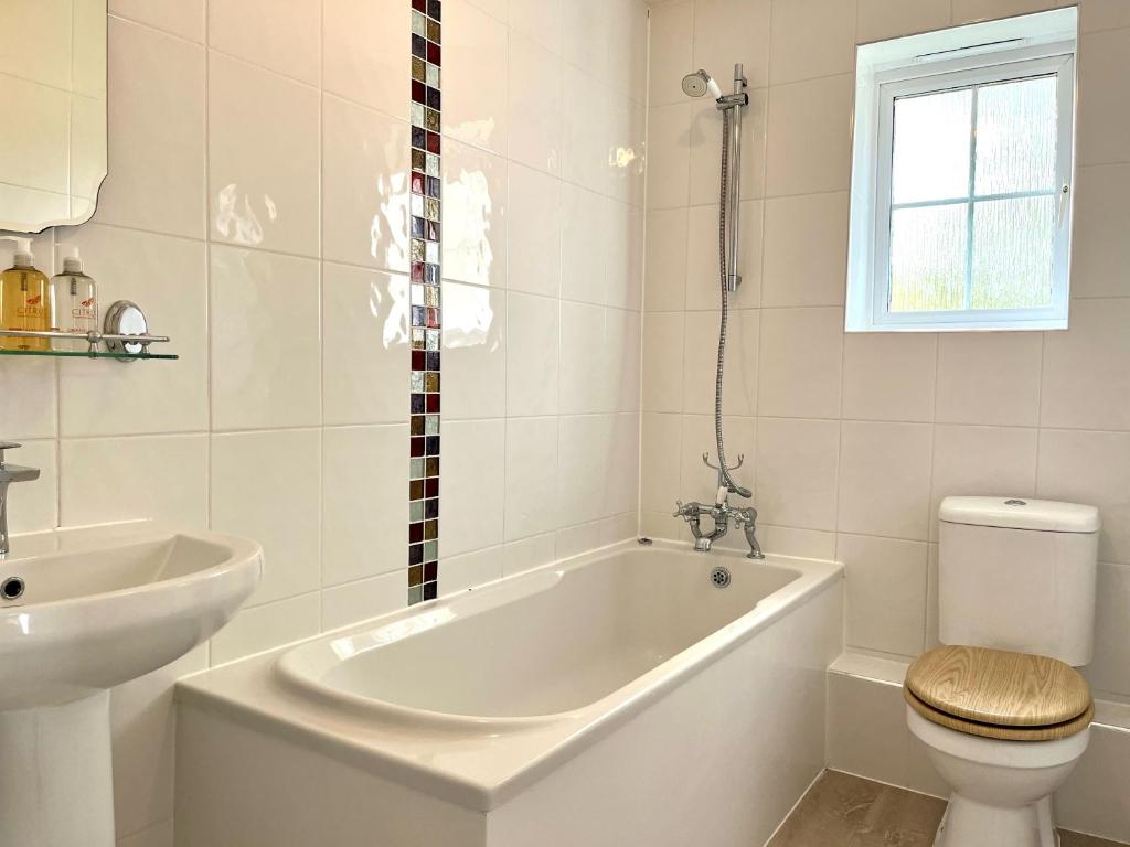 比斯特Comfortable 3 bedroomed house in Bicester的带浴缸、卫生间和盥洗盆的浴室