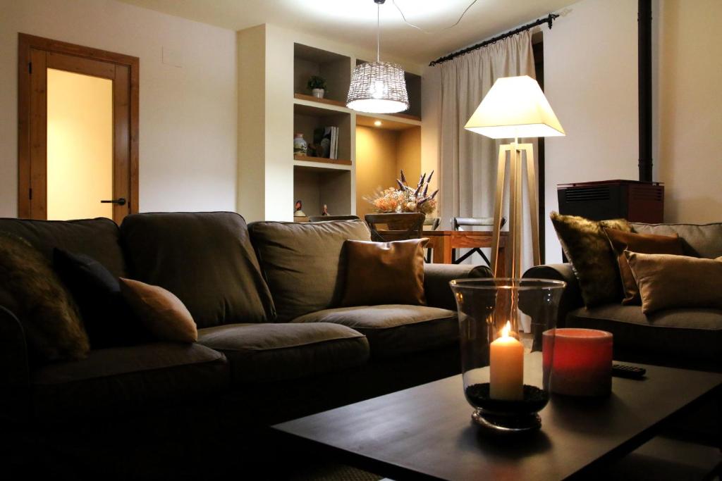 瓦伦西亚德奥尼Apartaments Lo Paller的带沙发的客厅和一张桌子上的蜡烛