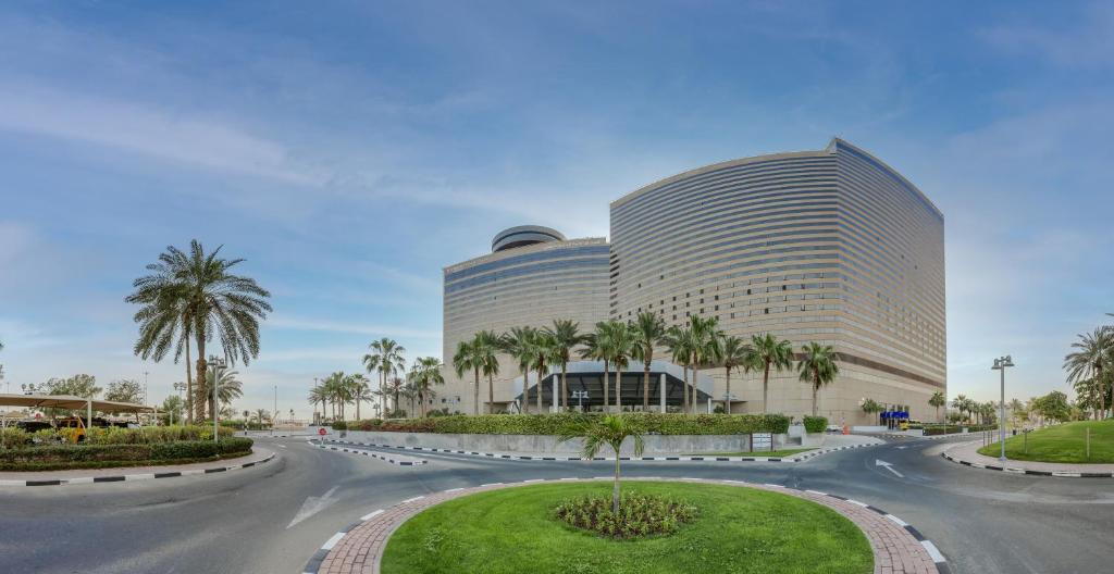 迪拜迪拜广场凯悦公寓式酒店的棕榈树建筑前的道路