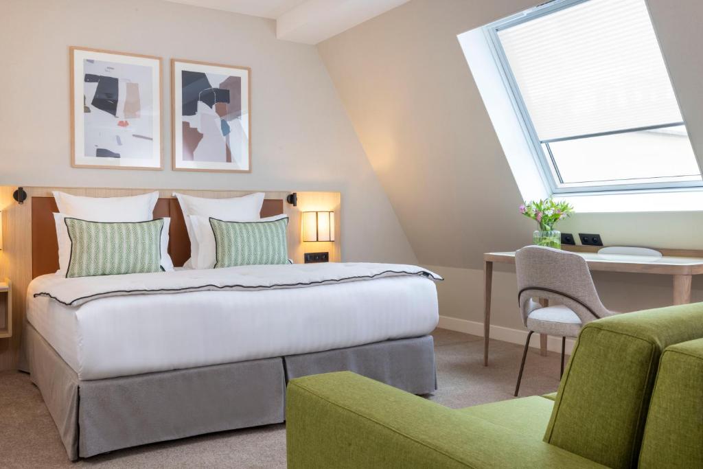 巴黎杜米妮旺多姆酒店的一间卧室配有一张床、一张书桌和一个窗户。