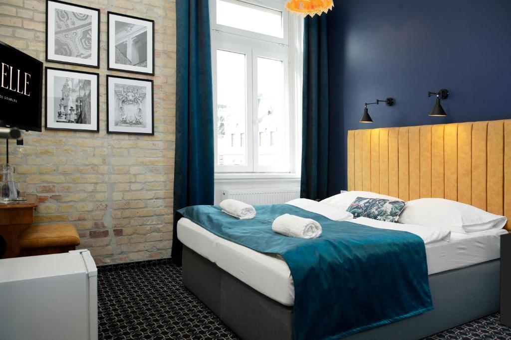 布达佩斯Giselle Vintage Doubles - Adults Only的一间卧室配有一张蓝色墙壁的床和一扇窗户