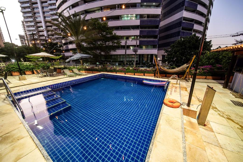 福塔莱萨宜必思福塔莱萨普拉亚德伊拉谢马酒店 的大楼前带吊床的大型游泳池