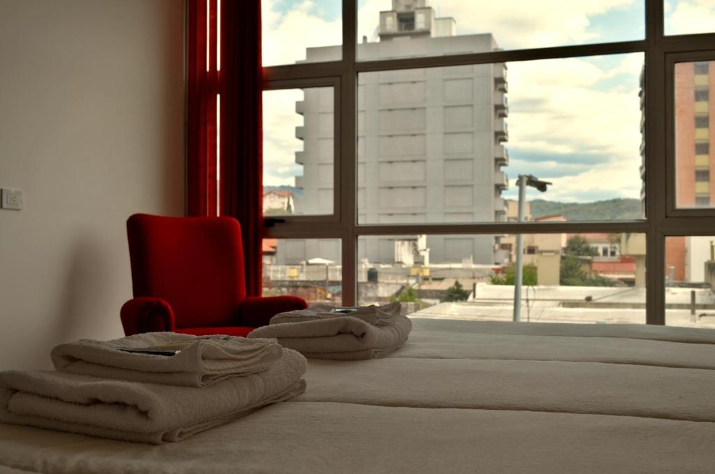 圣萨尔瓦多德朱Parque Hotel的带红色椅子的床和窗户的房间
