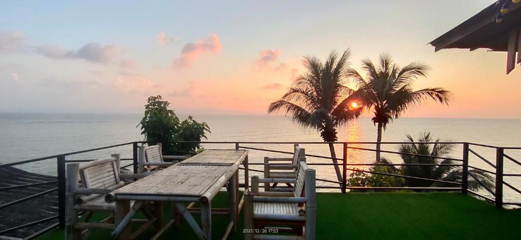班泰帕岸岛金滩度假酒店的俯瞰大海的阳台配有一张木桌和椅子