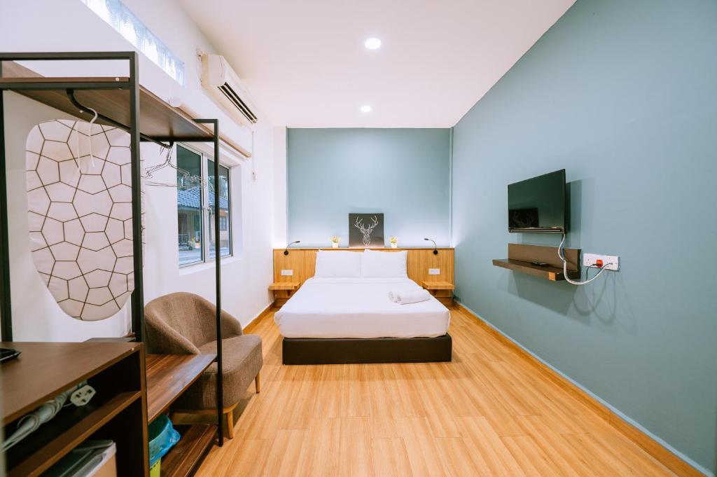 瓜埠Chill Box Langkawi的一间卧室配有一张床、一张沙发和一台电视。