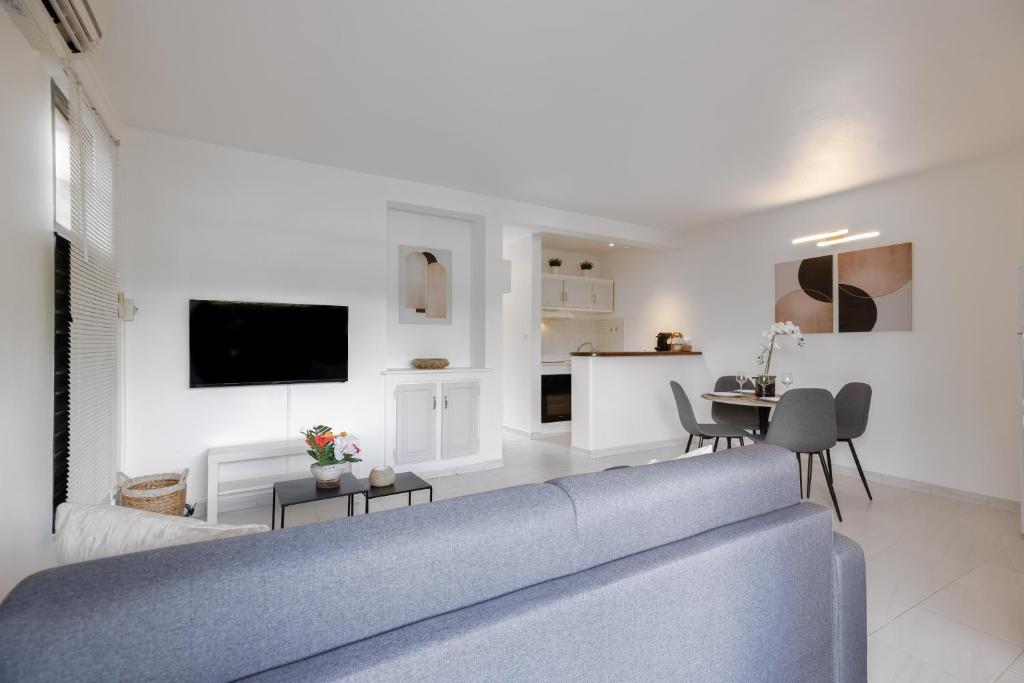 莱特鲁瓦西莱Eirene - Trois Ilets的一间带蓝色沙发的客厅和一间厨房