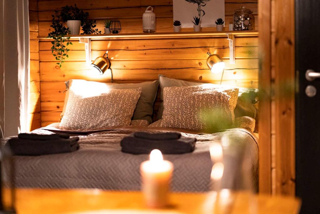 汉科Cottage by the sea的一间卧室配有一张带两张蜡烛的床。
