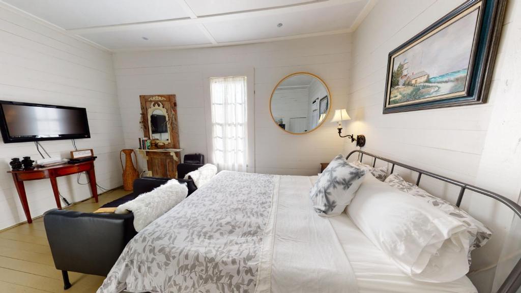 尤福拉THE FARMHOUSE private apartments的卧室配有白色的床和镜子