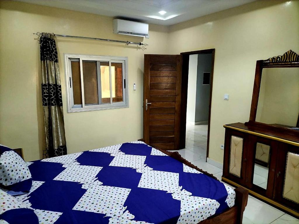 达喀尔Maison d'Hôtes entière Cité Douane Golf Dakar的卧室配有蓝色和白色的床和镜子