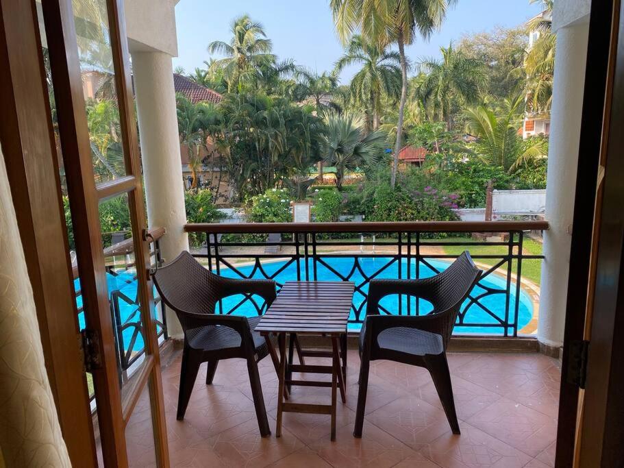贝托贝提姆2BHK Pool Facing Beachside Luxury Homestay In South Goa的一个带桌椅的阳台和一个游泳池