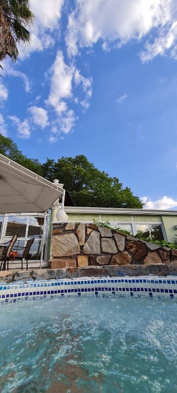 萨尔塔帕拉西奥埃斯孔迪多部门精品酒店的一座房子旁的游泳池,设有石墙
