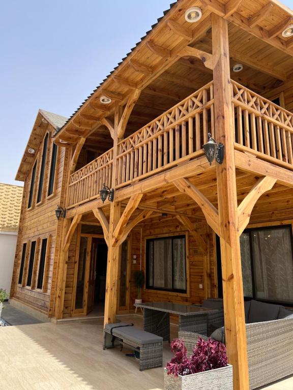 阿哈达أكواخ غيم ومطر的大型木制房屋,设有大型甲板
