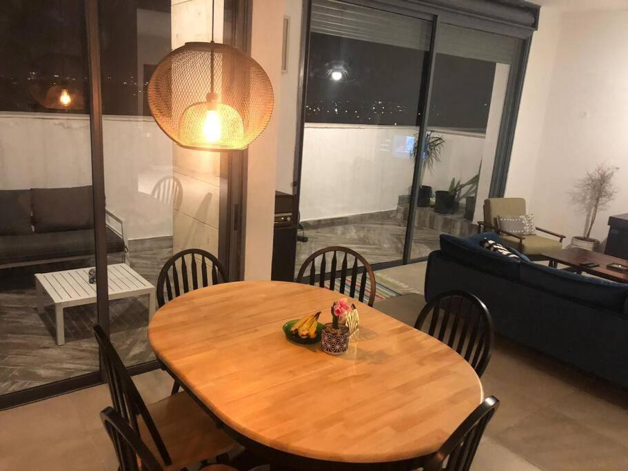 赖阿南纳Stunning four bedroom duplex in central Raanana的客厅配有一张木桌和椅子