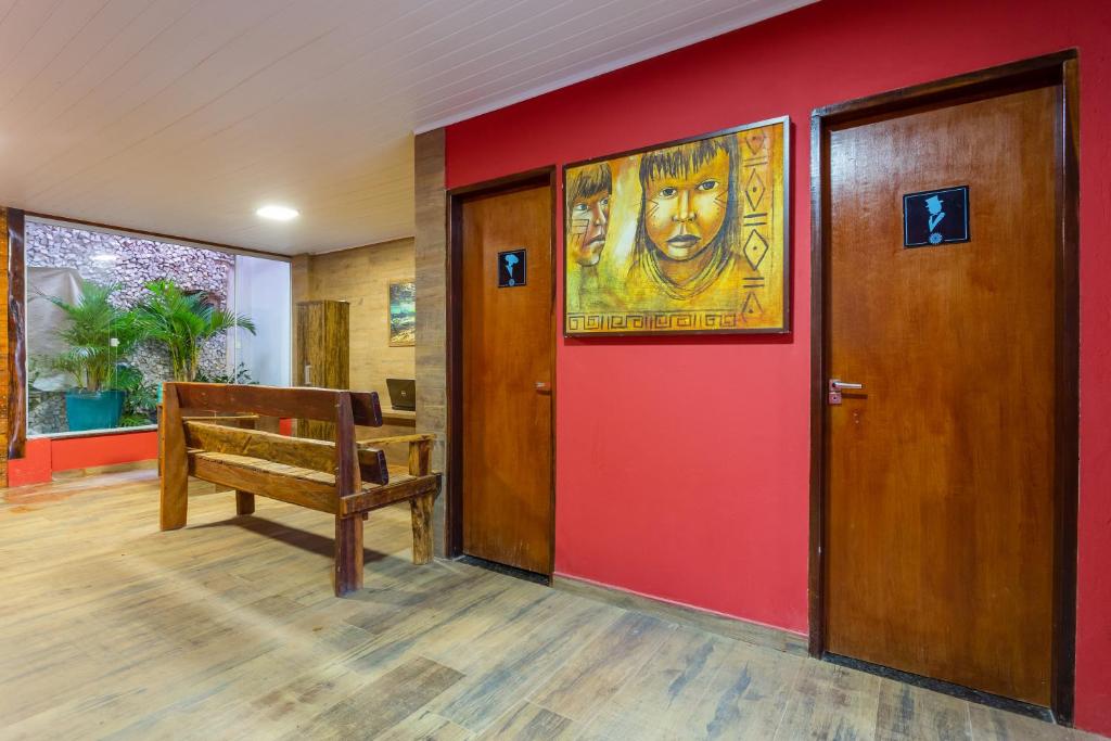 博尼图POUSADA SALOME的一间设有红色墙壁、长凳和绘画的房间