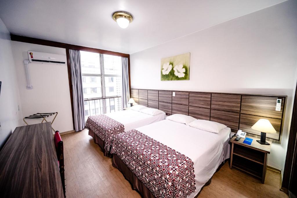 圣保罗Hotel Dan Inn Planalto São Paulo的一间卧室设有一张大床和一个窗户。