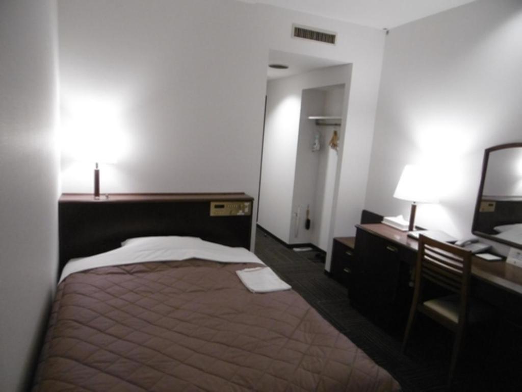 二本松Urban Hotel Nihonmatsu - Vacation STAY 78328v的一间卧室配有一张床、一张书桌和一台电视