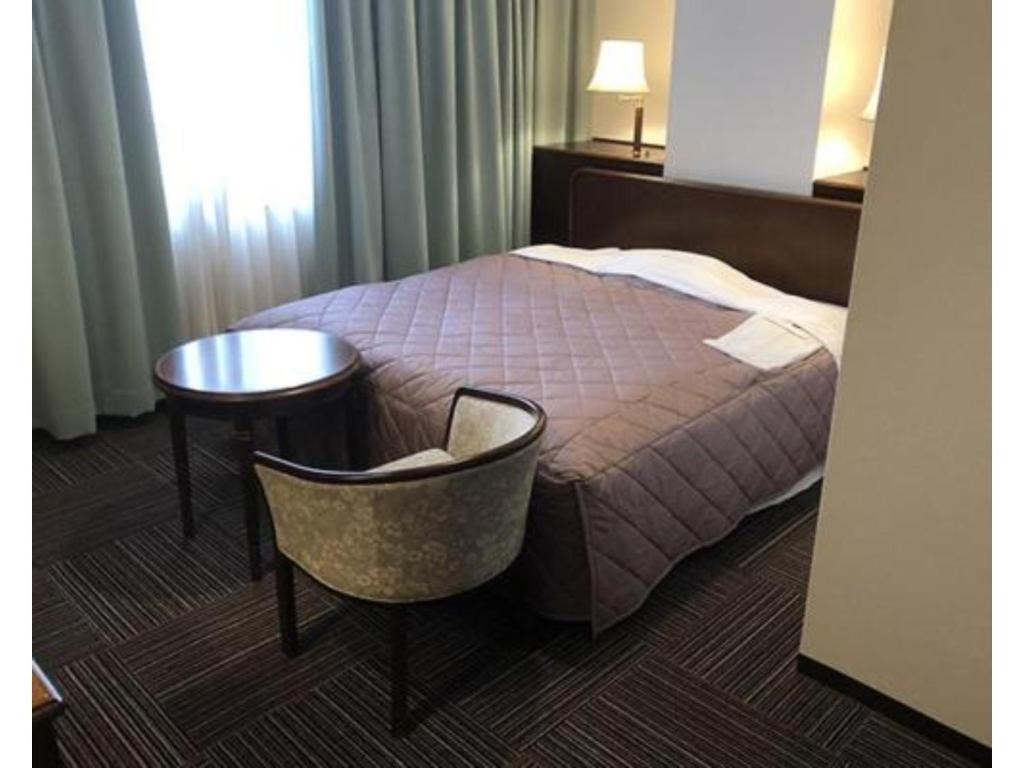 二本松Urban Hotel Nihonmatsu - Vacation STAY 78342v的酒店客房,配有床、桌子和椅子