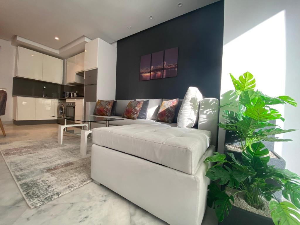 卡萨布兰卡CORNICHE CASABLANCA - SUBLIME F2 NEUF的一间带白色沙发的客厅和一间厨房