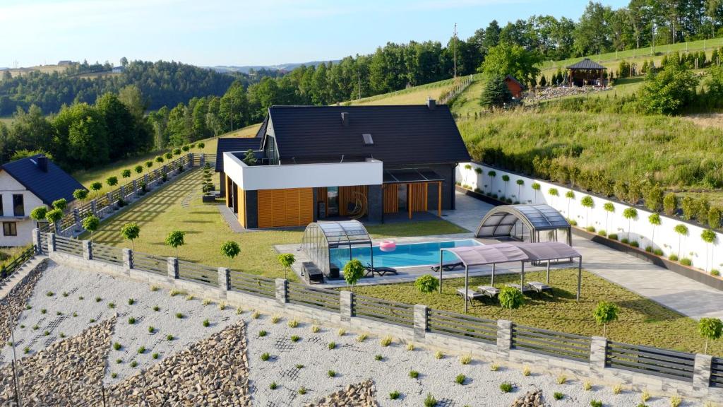 新松奇BLACK ROCKS domki na wynajem的享有山丘上房屋的空中景致,设有游泳池