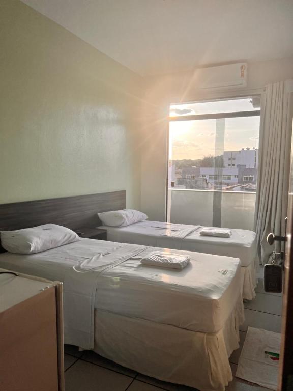 IbiapinaHotel Pinheiro的带窗户的客房内的两张床