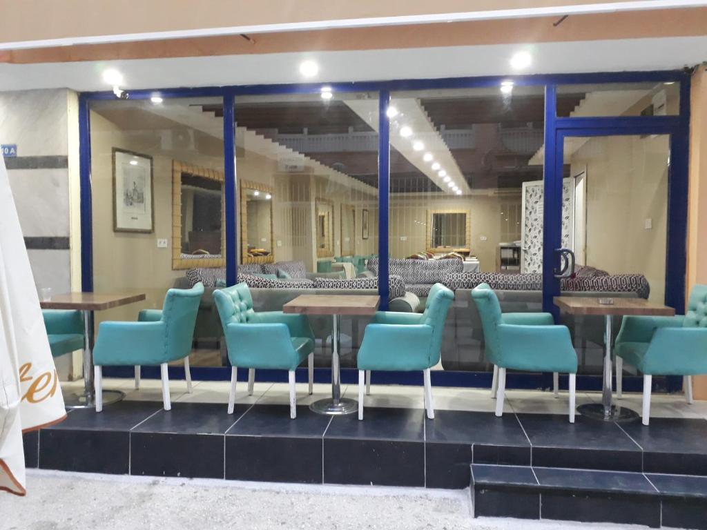 安塔利亚Nest Hotel ANTALYA的一间在房间内配有蓝色椅子和桌子的餐厅