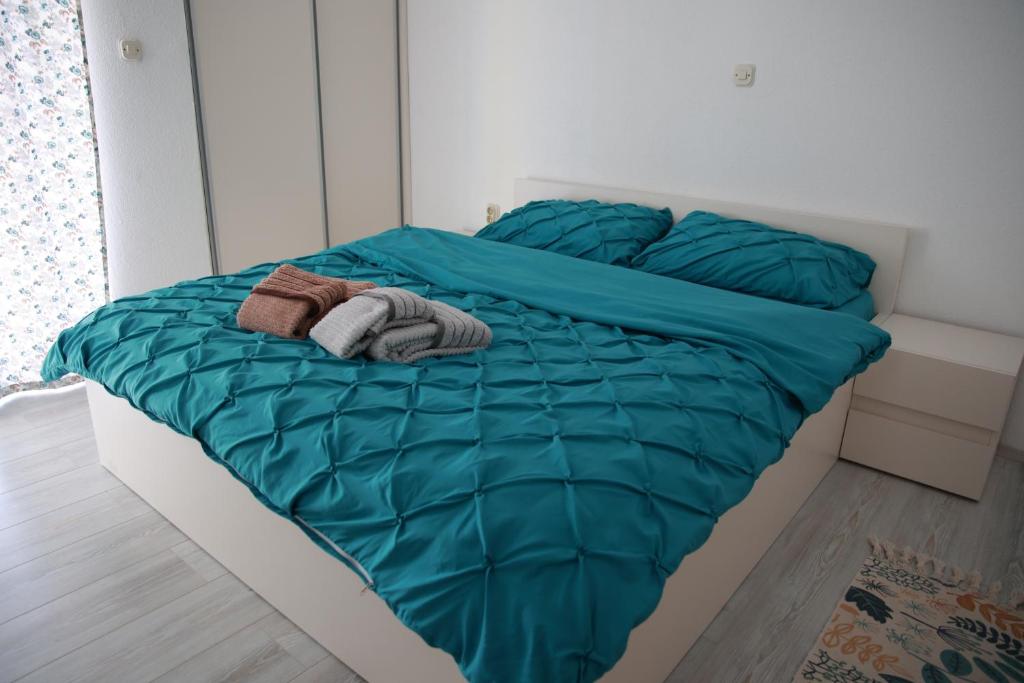 普里莱普Cavleski apartment的一张带绿棉被的床和两条毛巾