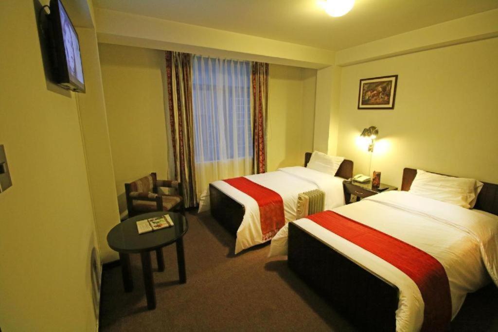 普诺Camino Real Puno的酒店客房设有两张床和电视。