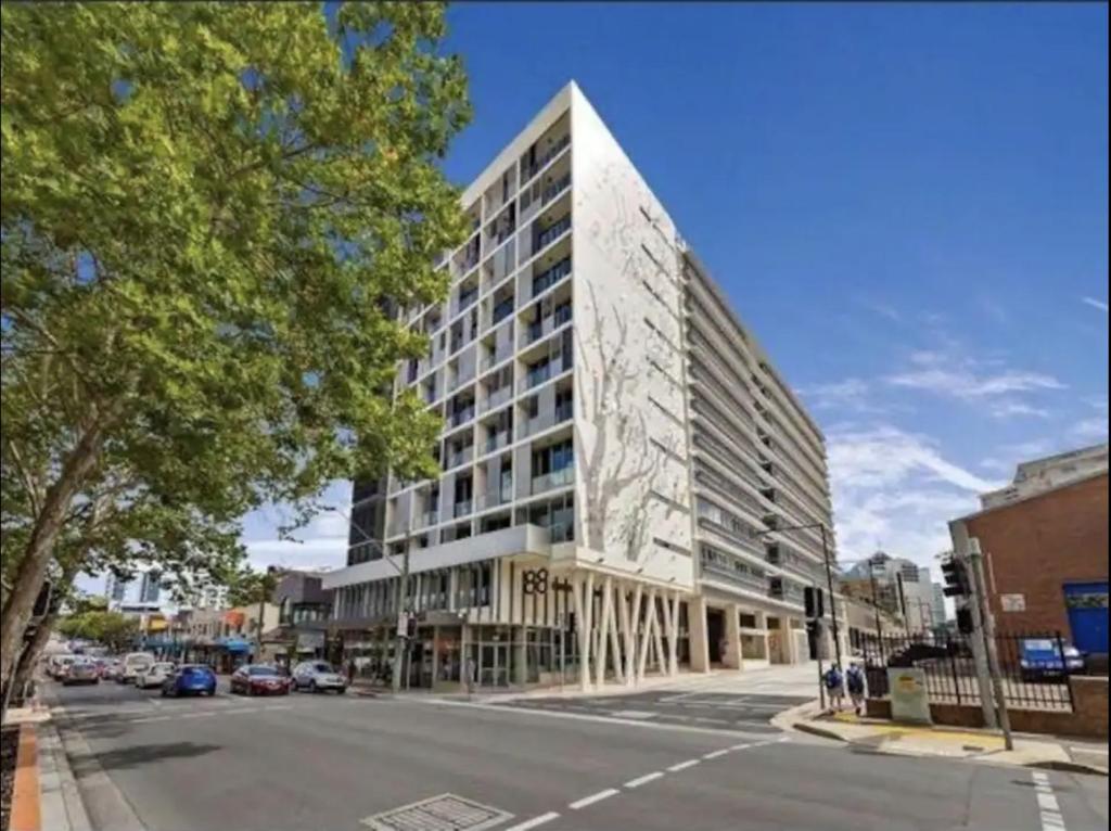 悉尼Broad Land Premium Apartments Chatswood Sydney的城市街道上一座高楼 ⁇ 染