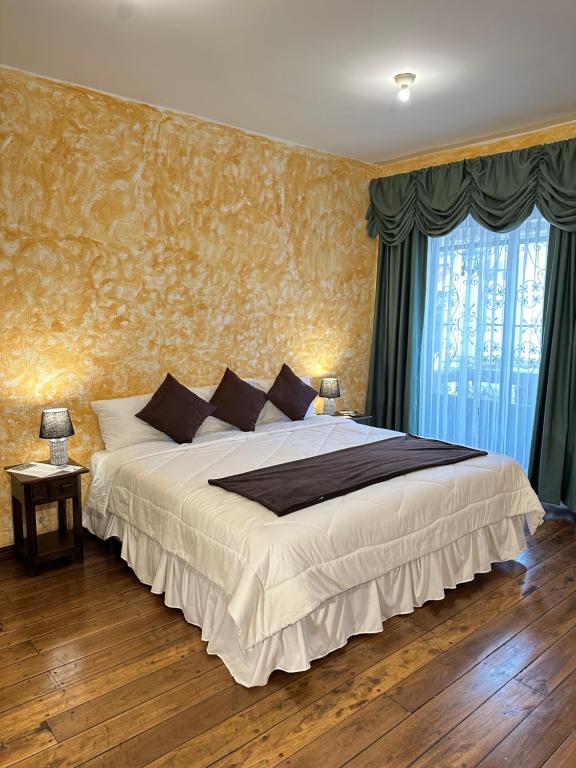昆卡NASS Central Garden的一间卧室配有一张带蓝色窗帘的大床