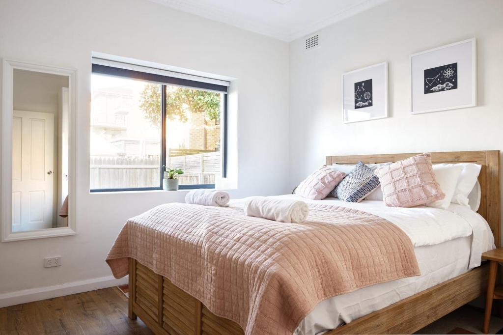 悉尼Manly Cosy Retreat - Short walk to beach的一间卧室设有一张大床和窗户