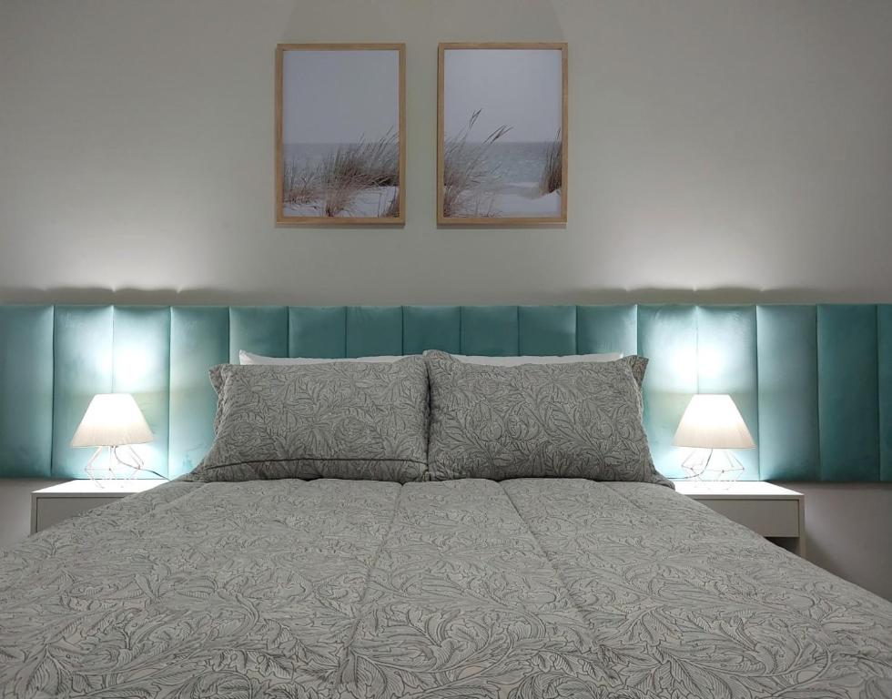阿雷格里港Aconchego e tranquilidade junto ao H. Mãe de Deus的卧室配有一张墙上有两张照片的床。