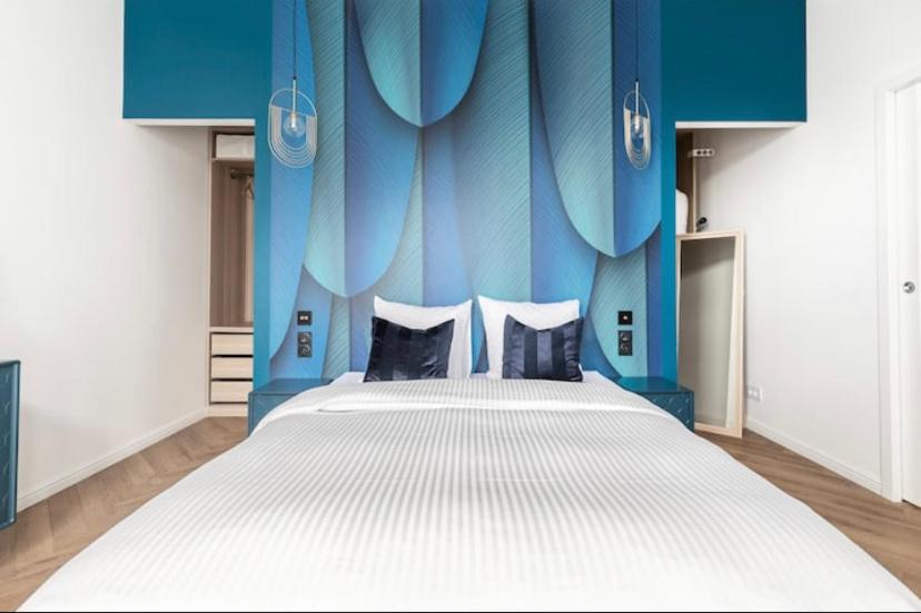 斯特拉斯堡Appart Deluxe Privé Strasbourg Centre avec Parking gratuit的一间卧室设有一张蓝色墙壁的大床