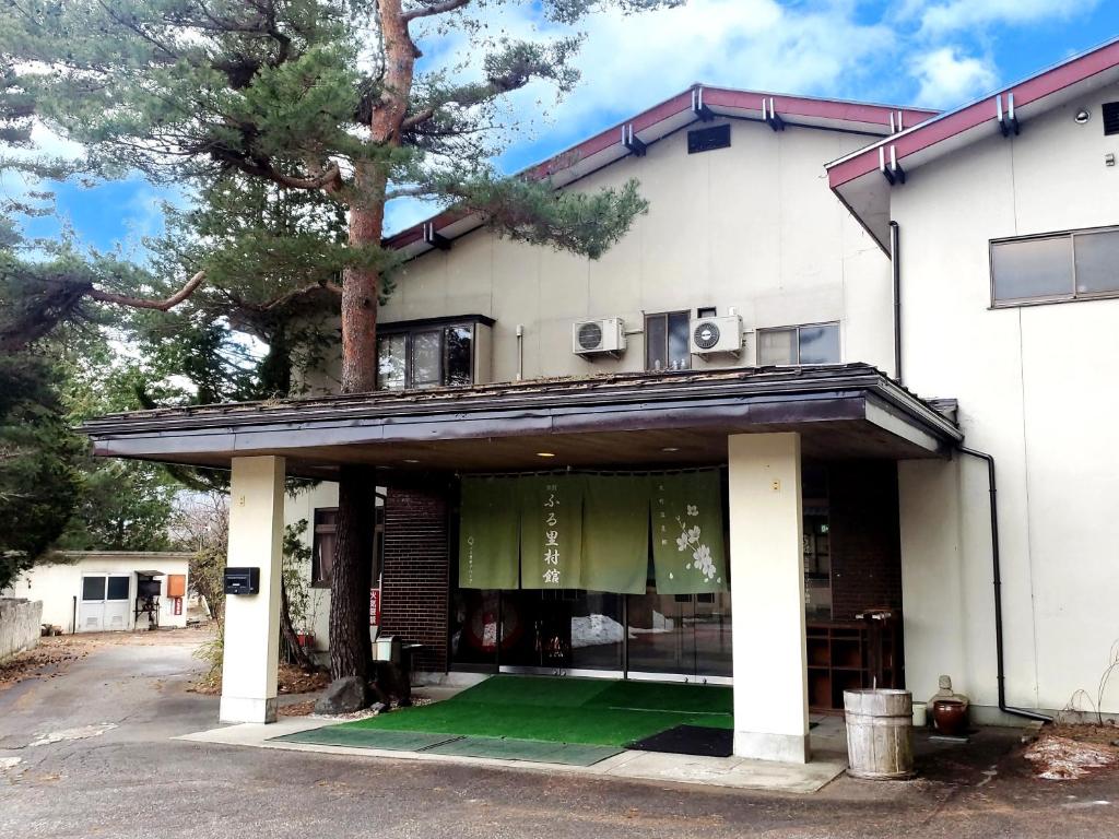 大町市Guest Room Furusatomura Kogeikan的前面有绿色草坪的房子