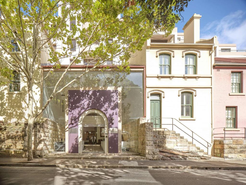 悉尼悉尼岩石区龙都酒店的白色建筑的入口,带紫色门