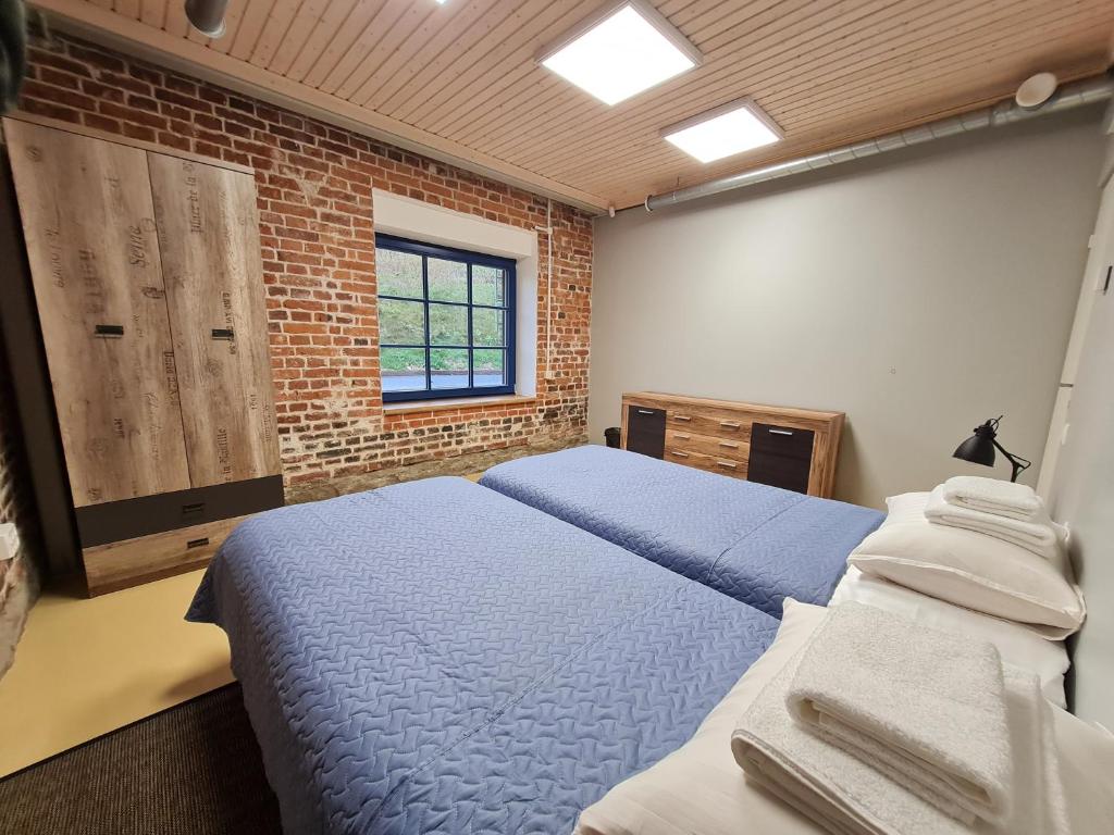 纳尔瓦Narva Port Hostel的一间卧室设有两张床和砖墙