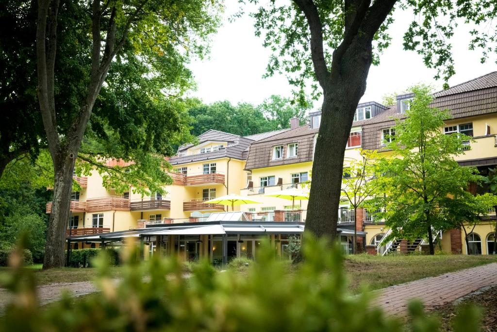 居斯特罗因瑟尔斯库尔豪斯酒店的前面有树木的黄色建筑