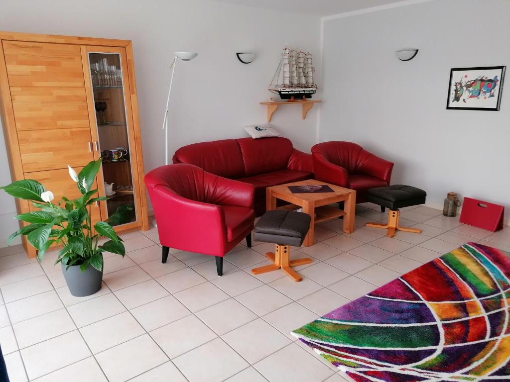 奥斯特巴德里克Ferienwohnung Andresen的客厅配有红色的沙发和桌子