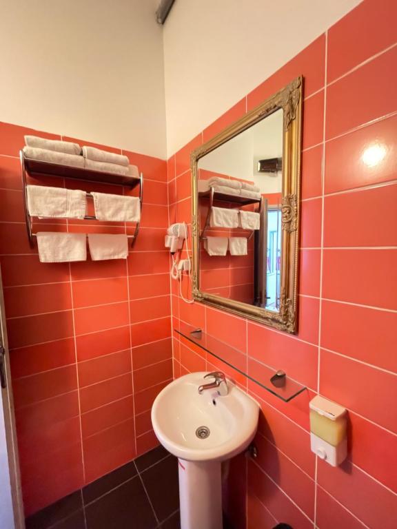尼什The Only One Apartments的红色的浴室设有水槽和镜子